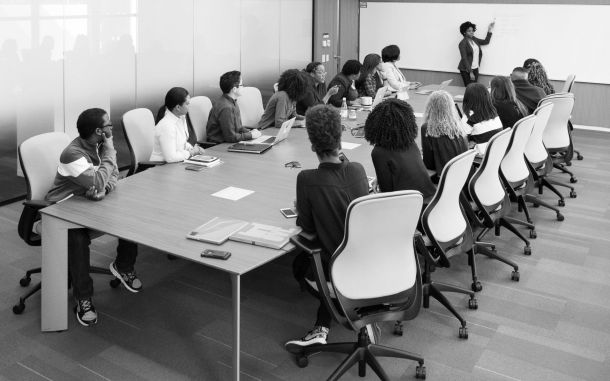 Woman presenting in a board room setting.