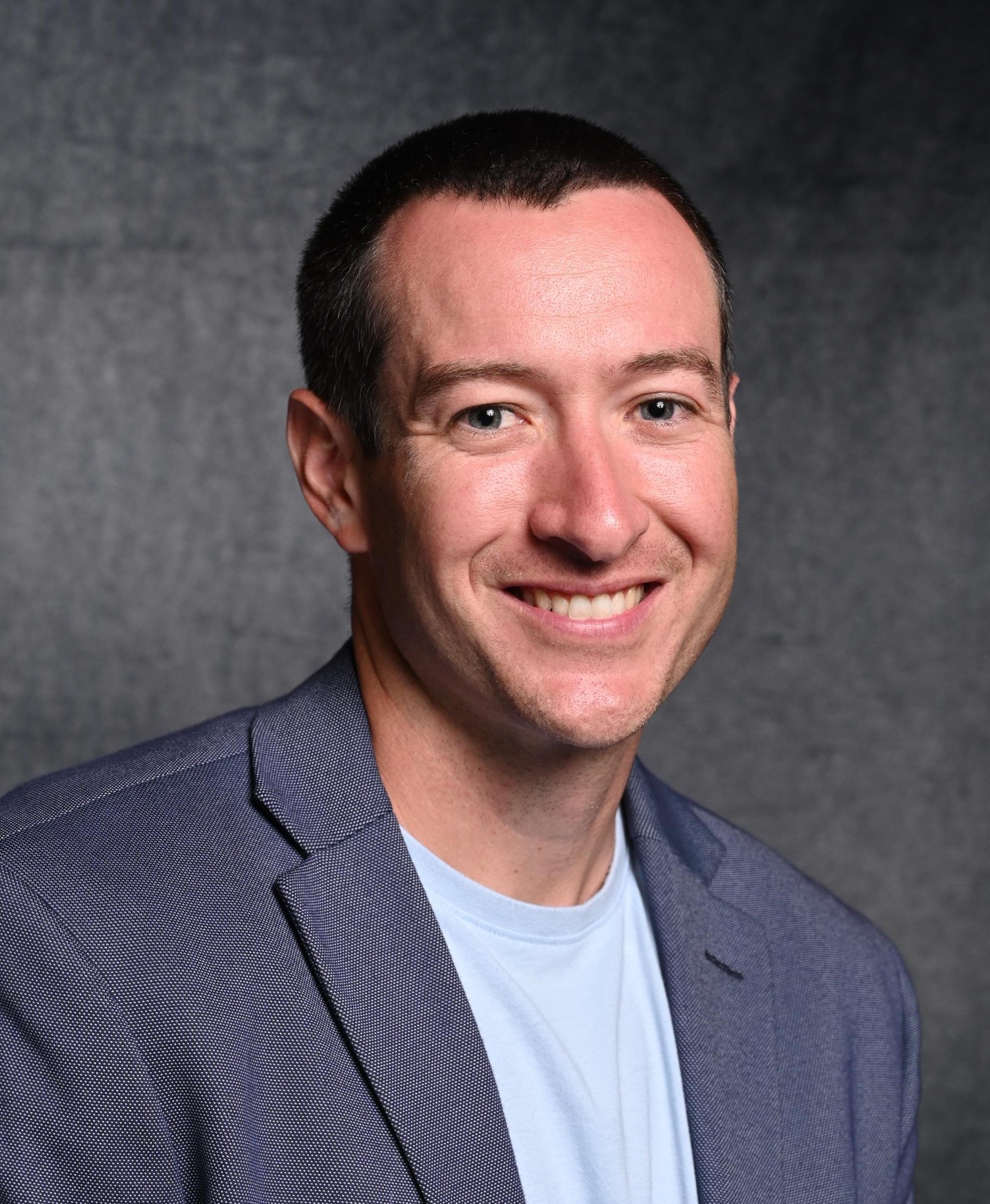 A man smiling for a professional headshot.