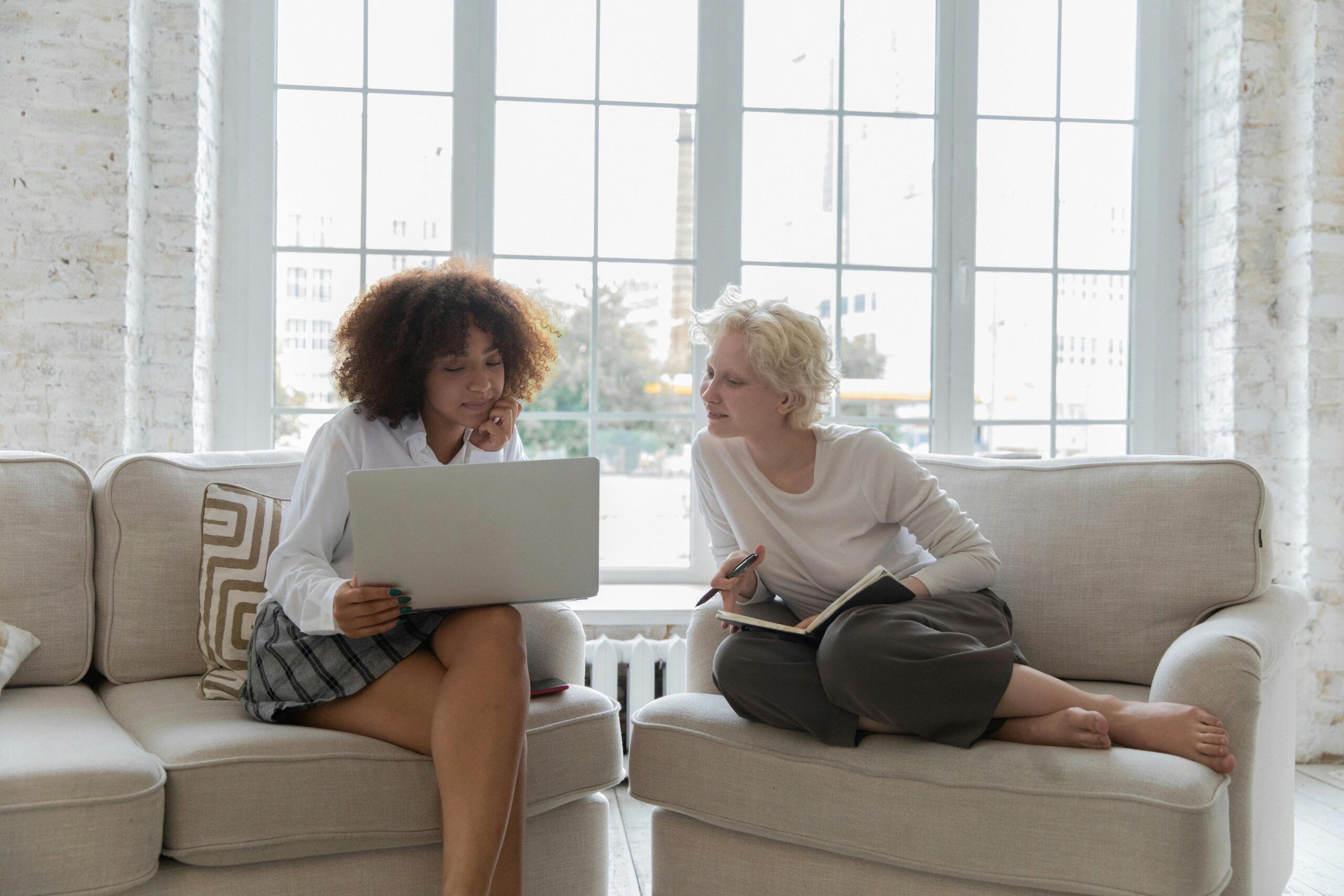 Two woman sitting together looking at a computer