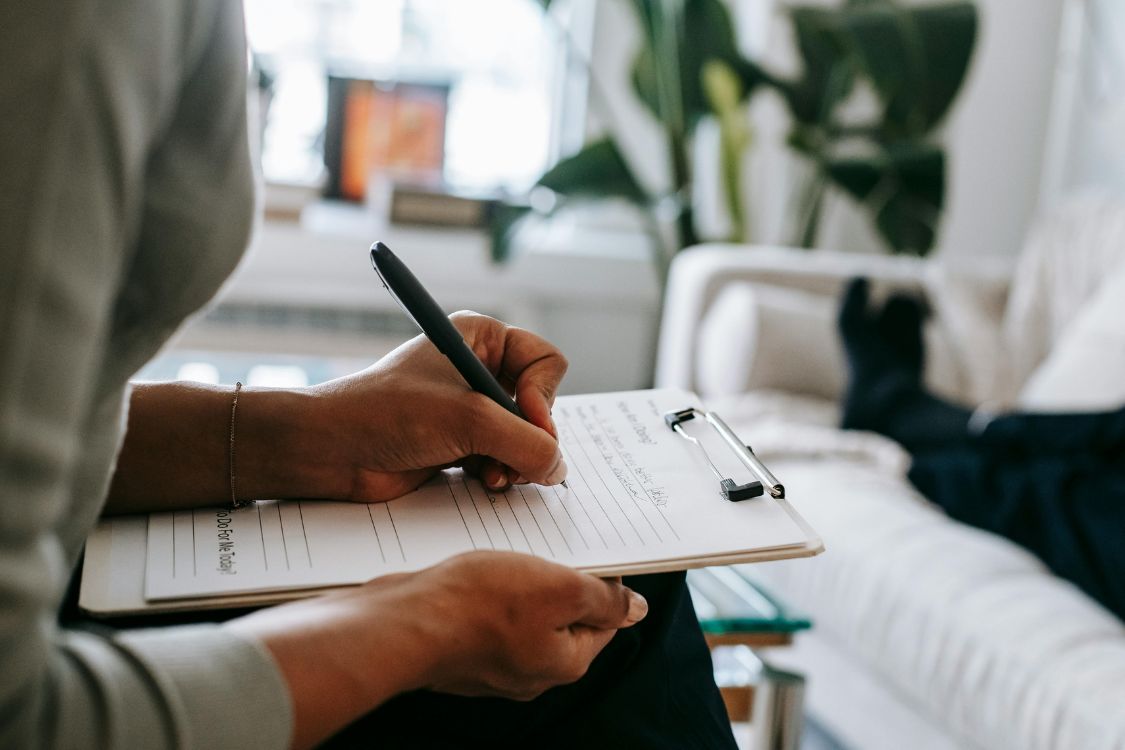 person writing on a clipboard