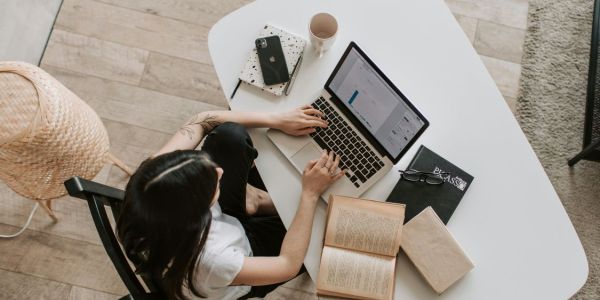 arial shot of person using computer at desk with books